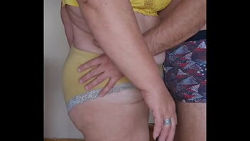 My wife, a voluptuous woman in her sixties, and I share a passionate kiss.